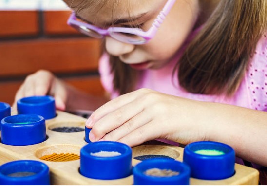 Young girl with glasses playing with puzzle