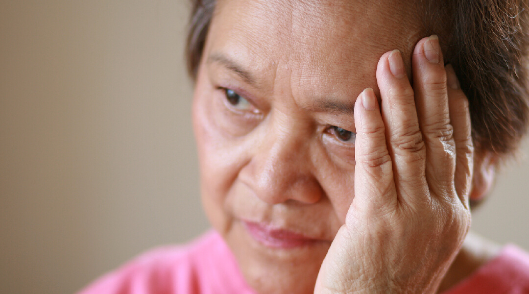 women with fingertips to forehead